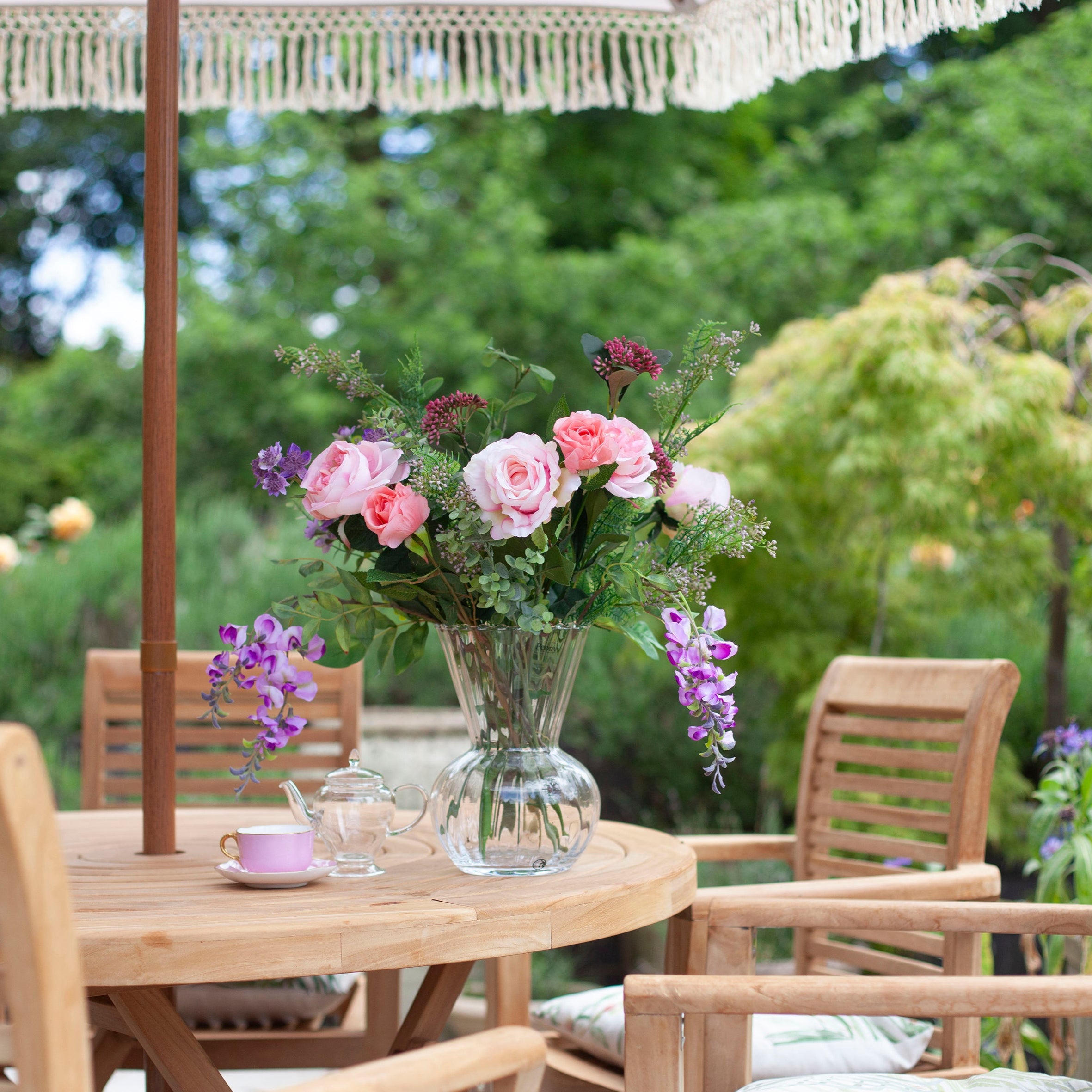 Artificial bouquet of pale pink roses, lavender wisteria, and astrantia with soft greenery,