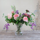 Artificial bouquet of pale pink roses, lavender wisteria, and astrantia with soft greenery,