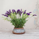 Artificial lavender arrangement with lifelike purple blooms and greenery, potted in a rustic bowl