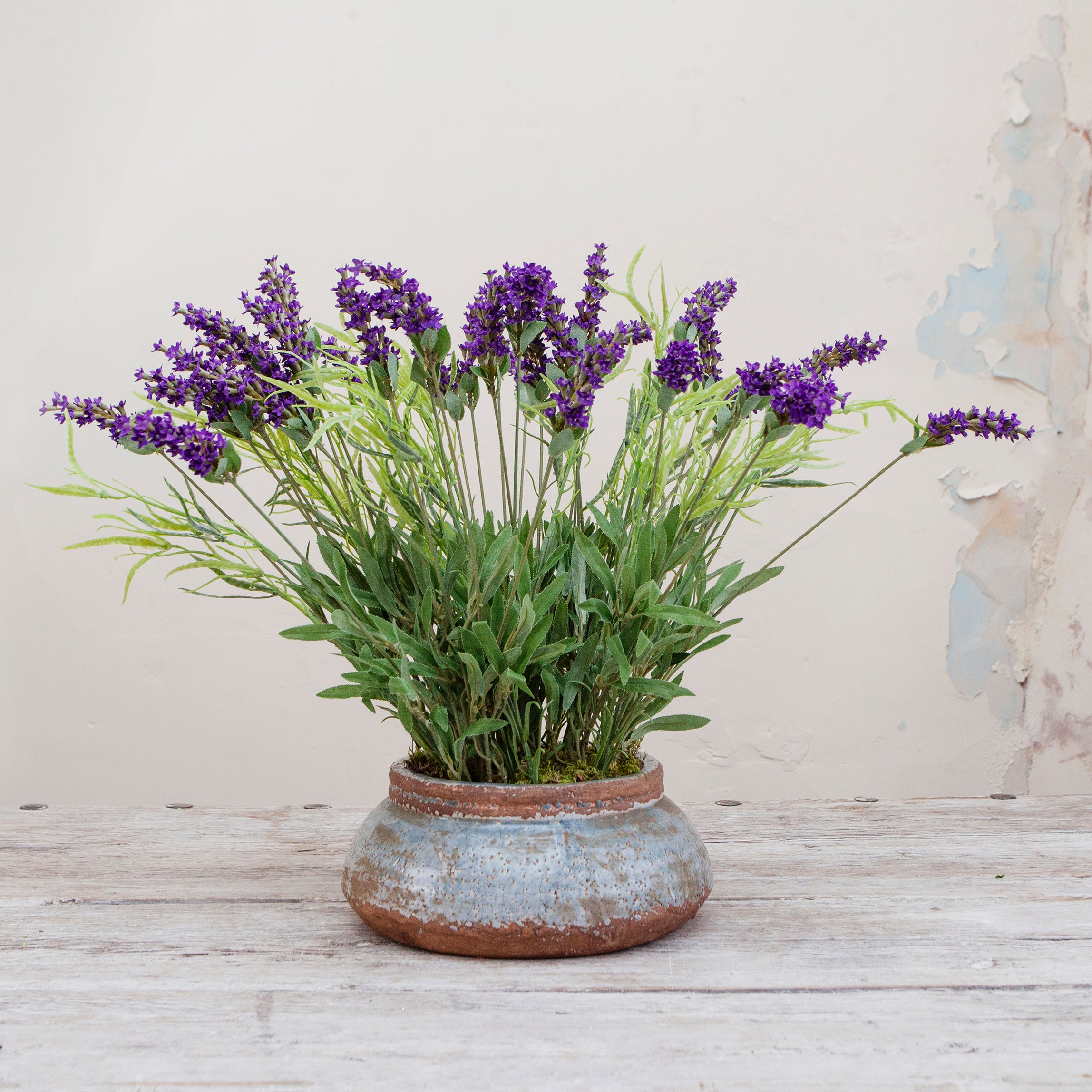 Artificial lavender arrangement with lifelike purple blooms and greenery, potted in a rustic bowl