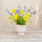 Artificial Spring flower arrangement with daffodils, bluebells and fritillaria in a white aged urn