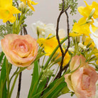 Artificial daffodil and ranunculus flower arrangement in a blue and white hand painted oriental jug