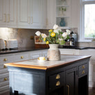 Artificial tulip and ranunculus flower arrangement in a rustic Roman style pot