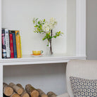 Artificial blossom stems arranged in a clear glass milk bottle vase