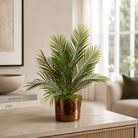 Artificial areca palm with realistic green fronds in a gold ceramic pot, styled on a console table in a neutral living room
