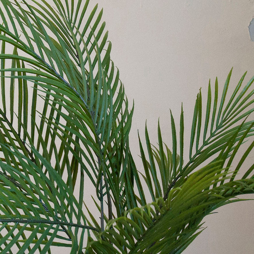 Close-up of realistic green fronds on an artificial areca palm