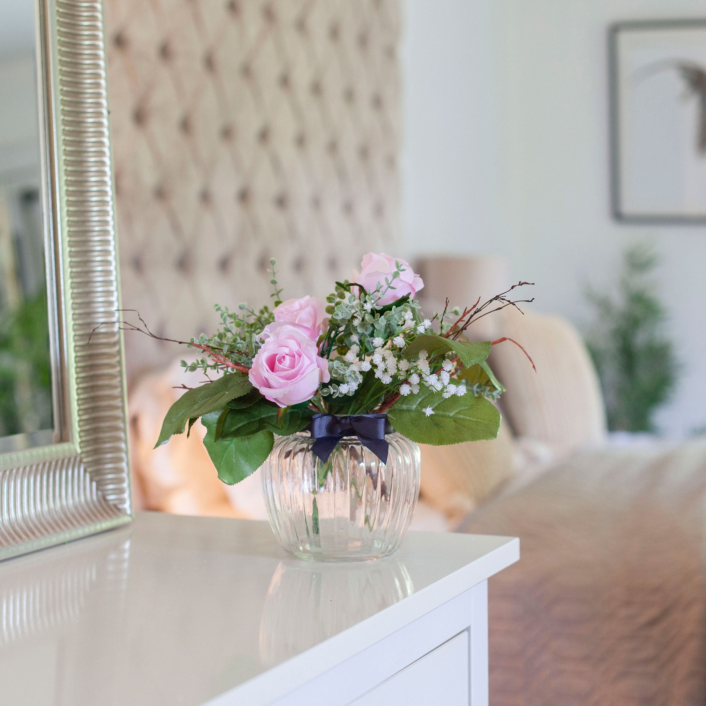 Artificial Pink Roses, Mini Eucalyptus & Gypsophila in Optic Jar Vase Gift Set, styled on a white console table in a softly lit neutral home interior.