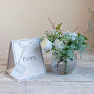 Artificial white roses, mini eucalyptus and gypsophila set in a clear optic glass jar vase with Peony gift bag.