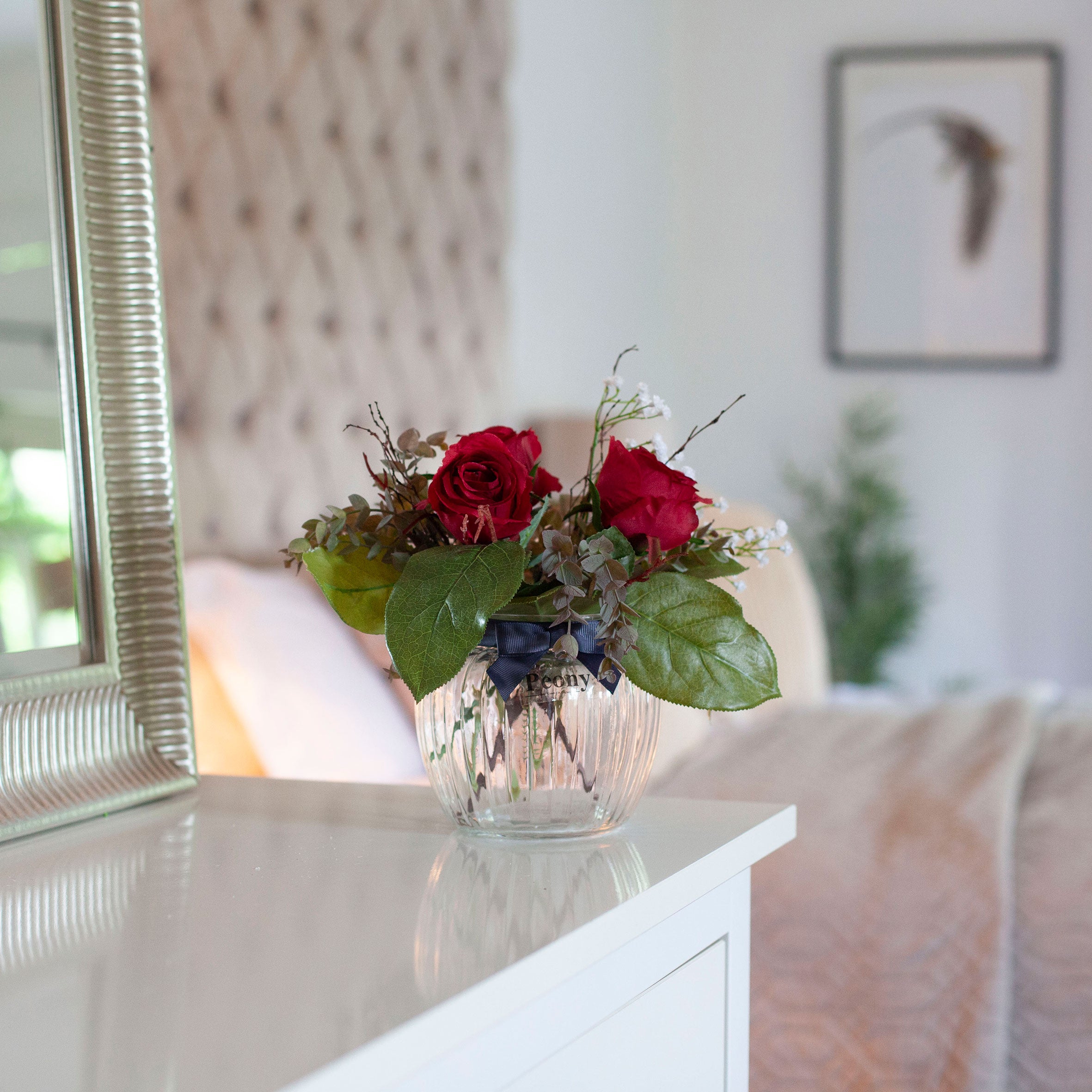 Artificial Red Roses, Mini Eucalyptus & Gypsophila in Optic Jar Vase Gift Set, styled on a white console table in a softly lit neutral home interior.
