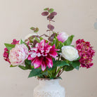 Close-up of an artificial hydrangea, dahlia and peony bouquet in pink, burgundy and white tones with realistic foliage.