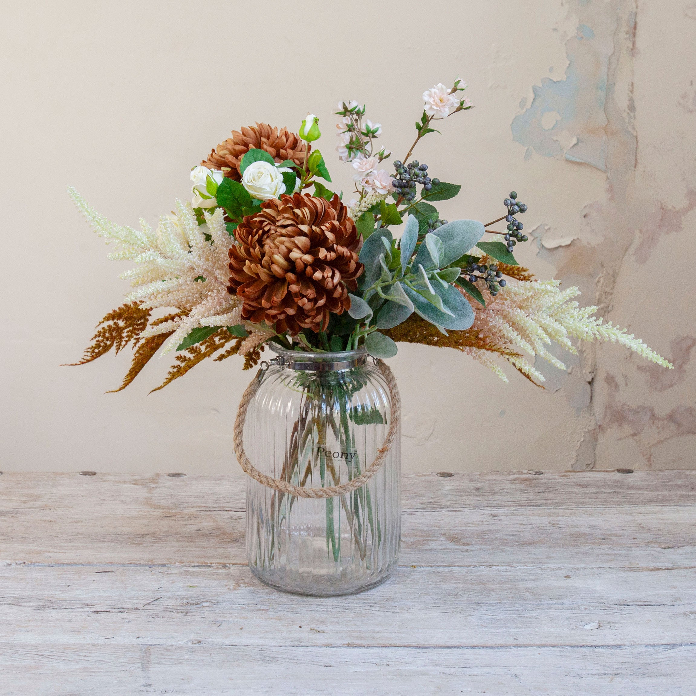 Artificial chrysanthemum, rose and astilbe bouquet in warm autumn tones, displayed in a clear glass rope vase available separately.