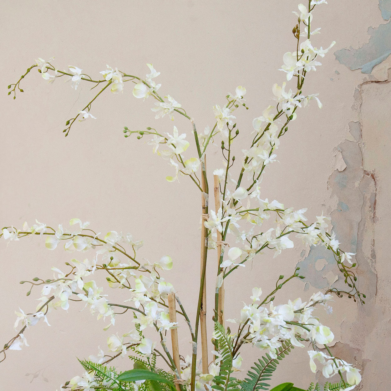 Close-up of artificial white dancing orchid flowers with realistic branching stems.
