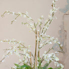 Close-up of artificial white dancing orchid flowers with realistic branching stems.