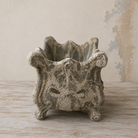 Scalloped square planter with an ornate design and distressed stone-effect finish.