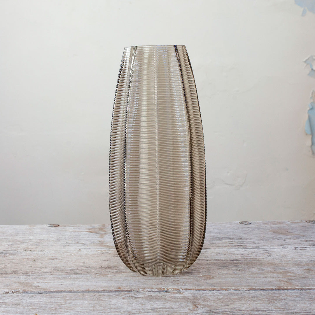 Smoked Tall Ridged Glass Vase with vertical ribbed texture on wooden table.