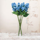 Artificial blue conehead hydrangea stems displayed together in a vase for styling purposes