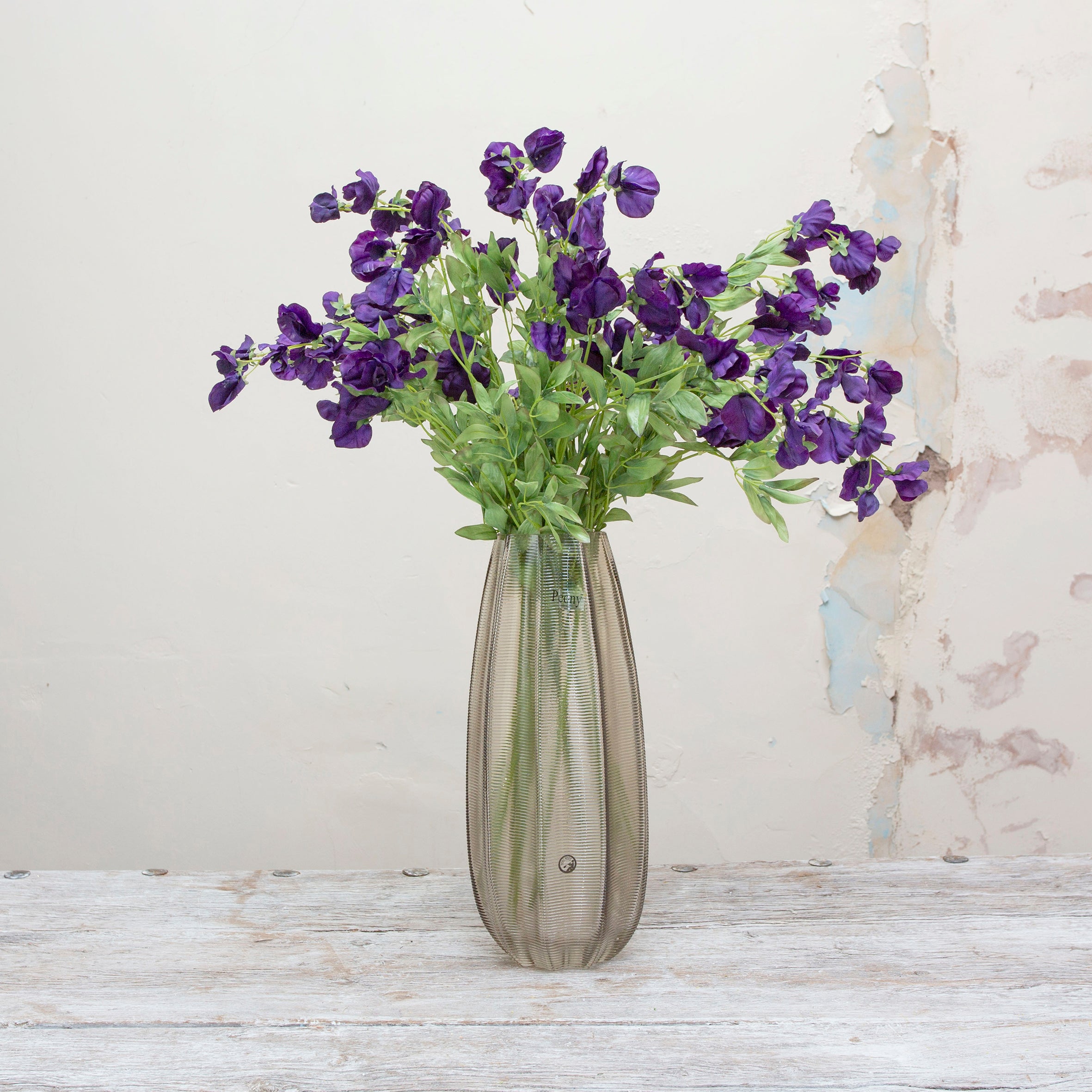 Artificial sweet pea stem displayed in a vase, showcasing elegant trailing stems with deep purple flowers for a dramatic yet romantic look
