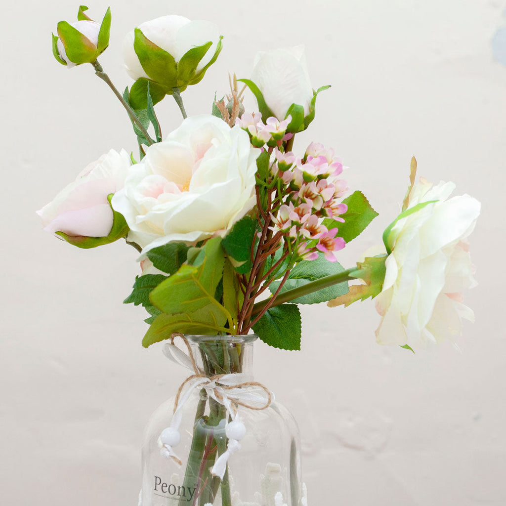 Roses and ranunculas with wax flowers in the lace bottle vase  Peony