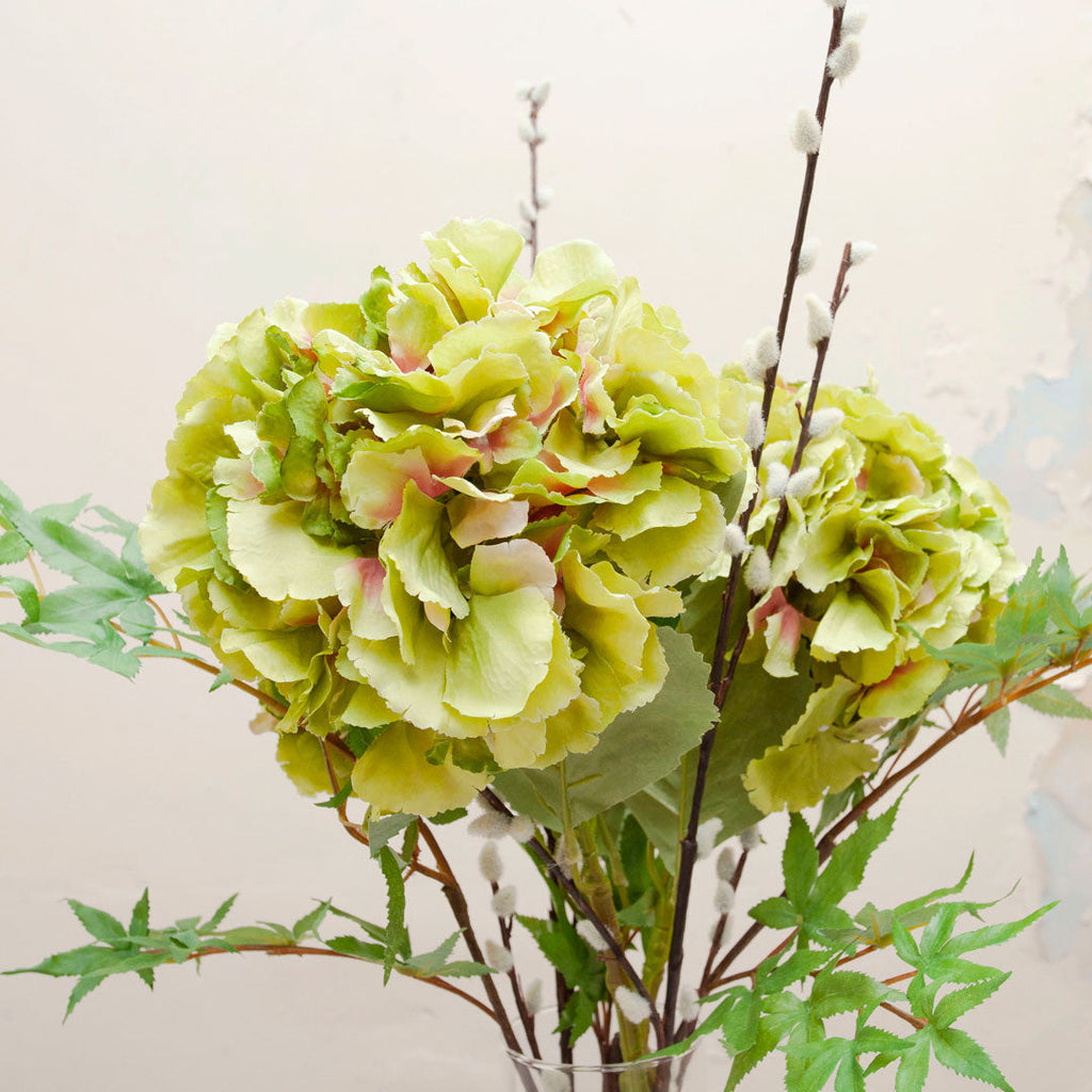 3 stems of hydrangeas with pussy willow in a tall cylinder vase Peony